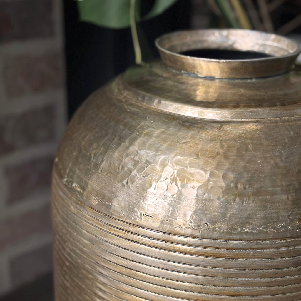 Close-up of a textured metallic vase with a blurred background