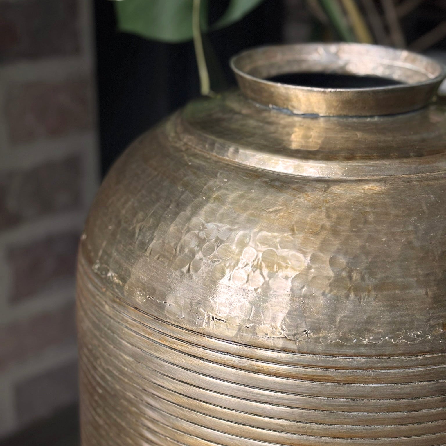 Close-up of a textured metallic vase with a blurred background